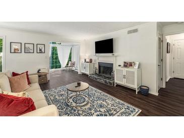 Bright living room featuring a fireplace, white walls, hardwood floors and a large window at 2703 Country Park Dr, Smyrna, GA 30080