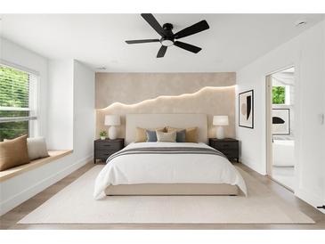 Bright main bedroom with ensuite bath, accent wall, ceiling fan, and large window seat at 32 Wadley Nw St, Atlanta, GA 30314