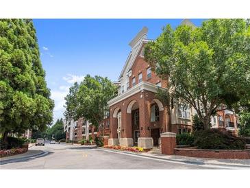 Charming brick apartment building featuring elegant archways, lush landscaping, and a welcoming entrance at 1850 Cotillion Dr Unit 3416, Atlanta, GA 30338