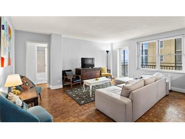 Bright living room features hardwood floors, large window, and comfortable seating arrangement at 300 Peachtree Ne St # 20 O, Atlanta, GA 30308