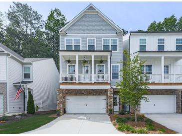 Charming home featuring a welcoming front porch, stone accents, and an attached two-car garage at 499 Bishop Ln, Woodstock, GA 30188