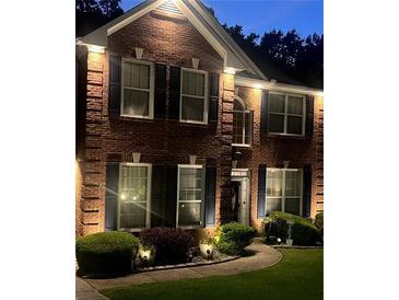 Charming brick home exterior, accentuated by stylish dark shutters and decorative outdoor lighting at 751 Stonecreek Way, Stone Mountain, GA 30087