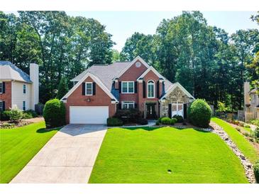Charming brick home with a well-manicured lawn and lush landscaping at 830 Club Chase Ct, Roswell, GA 30076