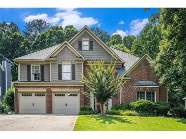 Charming two-story home featuring a brick and siding exterior, well-manicured lawn, and an attached two-car garage at 3117 Blowing Wind Nw Ct, Acworth, GA 30101