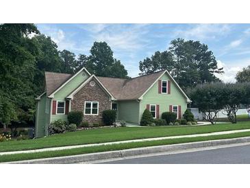 Charming home with a stone facade and red shutters on a well-manicured lawn at 4185 Lenox Park Dr, Buford, GA 30519
