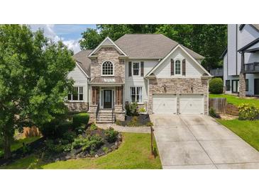 Charming two-story home with stone and siding exterior, landscaped front yard, and a two-car garage at 454 Pine Bluff Dr, Dallas, GA 30157