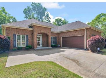 Charming brick home with a two-car garage, beautiful landscaping, and a well-maintained lawn at 570 Mcgarity Dr, Mcdonough, GA 30252