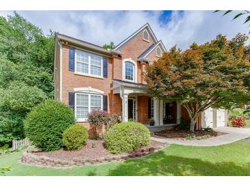 Charming brick home with a manicured front yard and mature landscaping creating great curb appeal at 457 Skiles Ct, Suwanee, GA 30024
