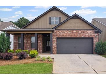 Charming brick and siding home with a covered front porch and attached two-car garage at 115 Court Xing, Locust Grove, GA 30248