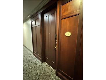 Apartment front door with dark wood finish, number 211, and decorative paneling at 77 Peachtree Ne Pl # 211, Atlanta, GA 30309