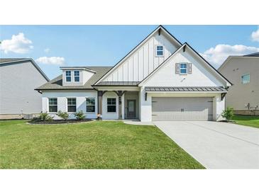 Charming two-story home featuring white brick, a well-manicured lawn, and a gray two-car garage at 35 Henson Farm Dr, Loganville, GA 30052