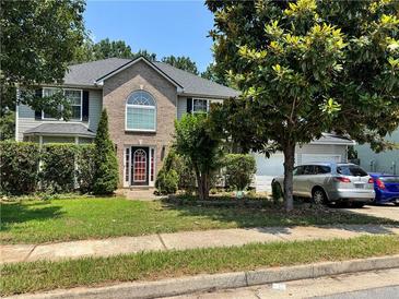 Charming two-story home with a brick facade, mature trees and well-manicured landscaping, offering great curb appeal at 3140 Ridge Hill Pkwy, Douglasville, GA 30135