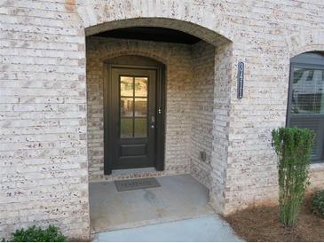 Charming brick home entrance with a welcoming black door, brick archway, and visible house number at 3411 Swallowtail Ter, Duluth, GA 30096