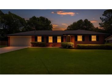 Charming brick home with a well-manicured lawn and inviting curb appeal at dusk at 3089 Ranlo Dr, Atlanta, GA 30340