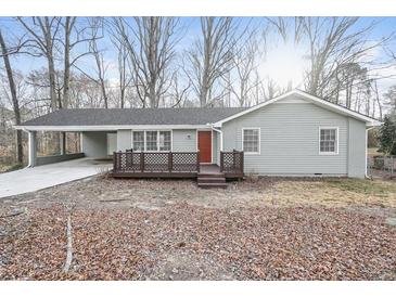 Charming single-story home featuring a carport, a cozy front porch, and a well-maintained yard at 3406 Blackberry Ln, Villa Rica, GA 30180