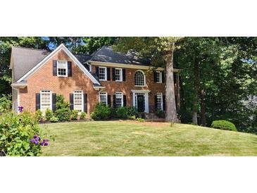 Elegant two-story brick home with manicured lawn, black shutters and a charming entrance framed by lush greenery at 4971 Fairhaven Ne Way, Roswell, GA 30075