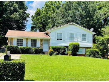 Charming home with white siding, well-manicured lawn, and mature trees providing ample shade at 8436 Magnolia Dr, Jonesboro, GA 30238