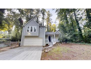 Charming two-story home with a well-maintained front yard and attached garage nestled among mature trees at 733 Emerald Forest Cir, Lawrenceville, GA 30044