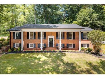 Inviting brick home featuring a white-columned front porch and mature landscaping for enhanced curb appeal at 2658 Briarlake Ne Rd, Atlanta, GA 30345