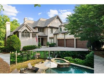 Elegant exterior featuring a three-car garage, white brick, and a stone chimney with a paved driveway and mature trees at 1525 Lockridge Dr, Cumming, GA 30041