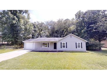 Charming single-story home featuring a well-manicured lawn and a welcoming front porch at 3136 Palomino Dr, Powder Springs, GA 30127