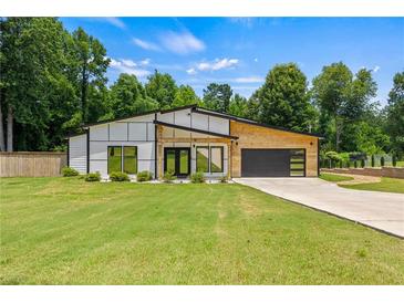 Stunning modern home with a well-manicured lawn and stylish architectural design at 90 Mckown Rd, Fayetteville, GA 30214
