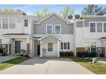 Charming two-story townhouse with grey and white exterior, a well-maintained lawn, and private driveway at 4457 Watson Ridge Dr, Stone Mountain, GA 30083