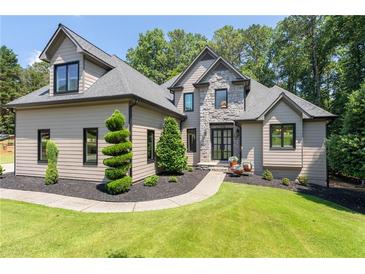 Beautiful home with well-manicured lawn and mature landscaping at 619 Lovinggood Trl, Woodstock, GA 30189