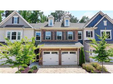 Charming brick townhome featuring a two-car garage and well-maintained landscaping at 315 Duval Dr, Alpharetta, GA 30009