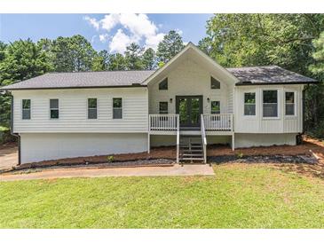 Charming renovated home with a gabled roof, front porch and manicured front lawn at 243 Hickory Way, Canton, GA 30115