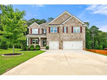 Charming two-story brick home with a well-manicured lawn and a spacious driveway leading to a two-car garage at 3865 Rifflepool Ct, Douglasville, GA 30135