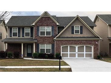 Charming two-story brick home with blue shutters, well-manicured lawn and two car garage at 3299 Arbor Oaks Dr, Snellville, GA 30039