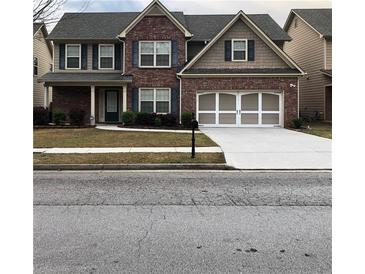 Charming two-story brick home with a well-manicured lawn and an attached two-car garage at 3299 Arbor Oaks Dr, Snellville, GA 30039
