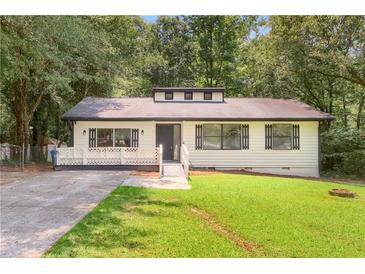Charming, one-story home featuring a well-manicured lawn and a welcoming front porch at 558 Newlin Ct, Lawrenceville, GA 30046