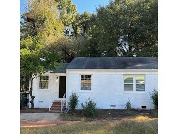 Charming, single-story home with a white brick facade, complemented by mature trees and a well-manicured front lawn at 1764 Cahoon St, Atlanta, GA 30310