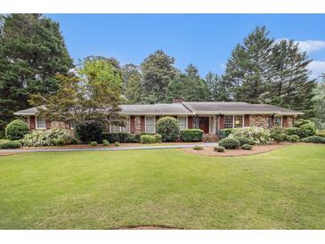 Charming single-story brick home featuring a lush green lawn and meticulously landscaped front yard at 2221 Fairoaks Rd, Decatur, GA 30033