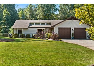Charming single-story home with well-manicured lawn and two-car garage offers great curb appeal at 195 Pine Trail Rd, Fayetteville, GA 30214