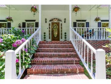 Inviting brick steps lead to the front door of this home with lush landscaping at 5491 Hiram Rd, Powder Springs, GA 30127