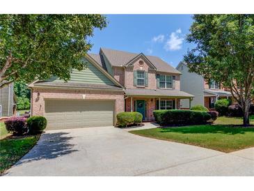 Charming two-story home with a brick facade, manicured lawn, and attached two-car garage at 3370 Battlement Cir, Loganville, GA 30052