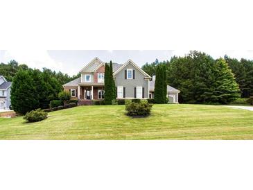 Charming home with a lush green lawn and mature trees offering curb appeal at 240 Chandler Walk, Loganville, GA 30052