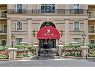 Elegant building entrance features a red awning and well-manicured landscaping for a welcoming feel at 2865 Lenox Ne Rd # 103, Atlanta, GA 30324