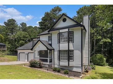 Charming two-story home with black and white trim, and a lush green lawn at 6492 Swift Creek Road, Lithonia, GA 30058
