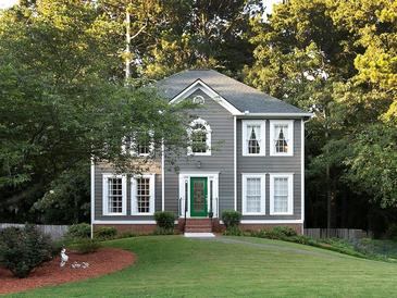 Charming two-story home featuring gray siding, white trim, manicured lawn, and lush landscaping at 4601 Gann Sw Xing, Smyrna, GA 30082