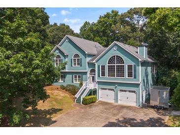 Charming two-story home boasts a two-car garage, well-maintained yard, and inviting staircase leading to the entrance at 533 Coolsprings Walk, Woodstock, GA 30188