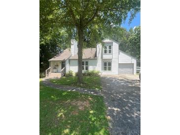 Charming two-story home featuring white siding, a well-maintained lawn, and a lush, mature tree in the front yard at 2500 Trent Dr, Marietta, GA 30066