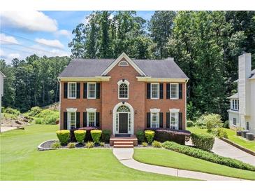 Charming brick home boasts a manicured lawn, black shutters, and a welcoming front entrance at 2500 Ashbourne Dr, Lawrenceville, GA 30043