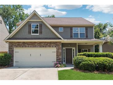 Charming two-story home featuring a stone facade, neutral siding, covered entryway, and an attached two car garage at 6202 Oakdale Ridge Se Ct, Mableton, GA 30126