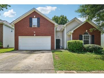Charming brick and vinyl home with a two-car garage and well-maintained lawn at 876 Ashton Oak Cir, Stone Mountain, GA 30083