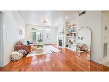 Bright living room with hardwood floors, fireplace, built-in shelves, and access to a balcony at 225 E Ponce De Leon Ave # 310, Decatur, GA 30030