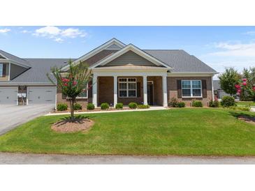 Charming home featuring brick facade, covered porch, and manicured lawn at 3209 Telhurst Way, Buford, GA 30519